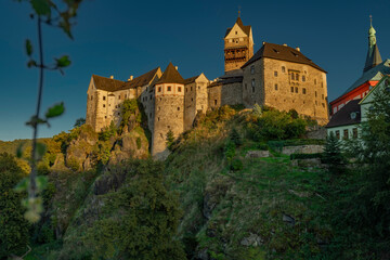 Fototapeta na wymiar Loket town with castle on hill and river Ohre around in autumn evening