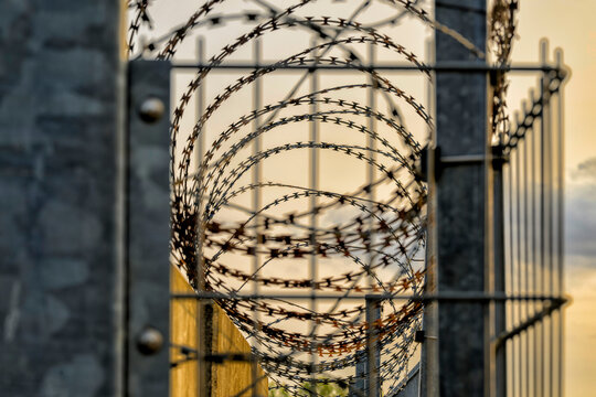 Absperrung durch eine Mauer , Zaun und Stacheldraht