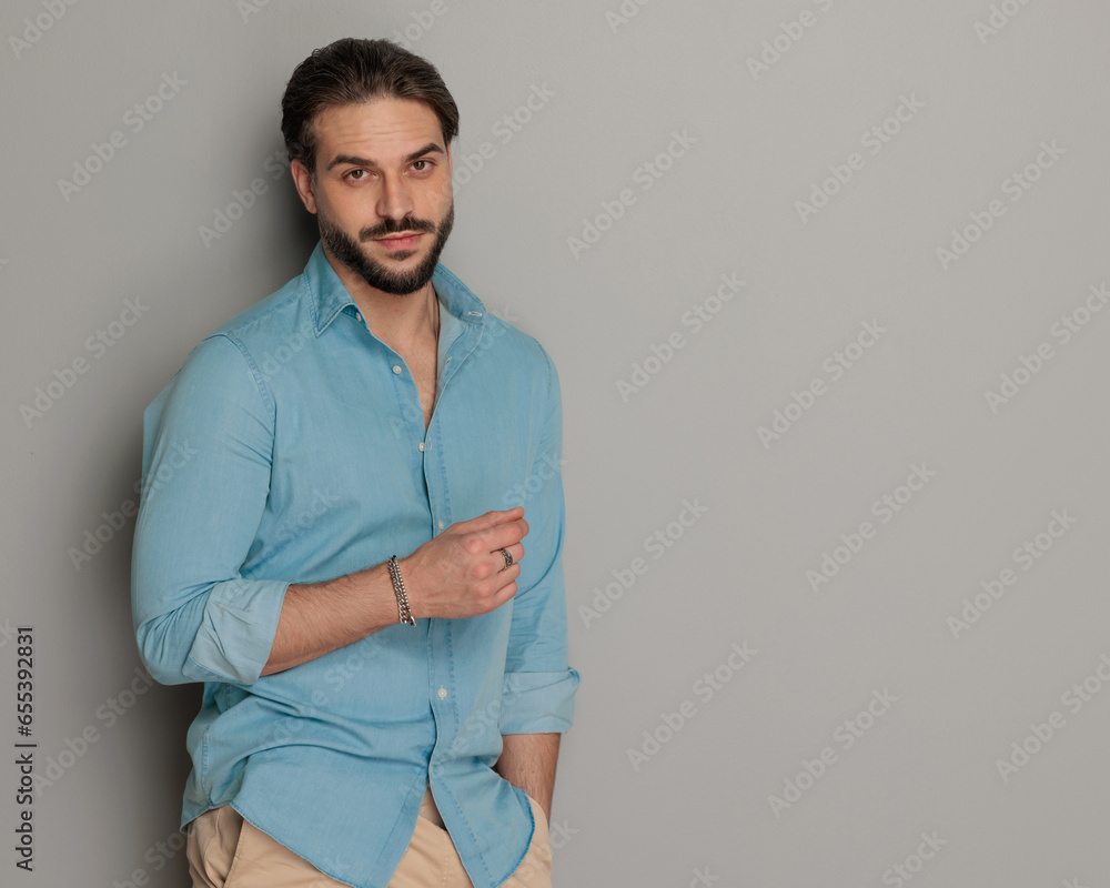 Wall mural bearded casual guy looking forward while holding hand in pocket