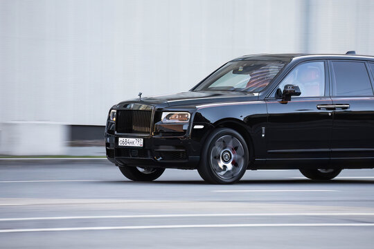 luxury car Rolls Royce Cullinan SUV in motion. Premium british auto drive fast, side view
