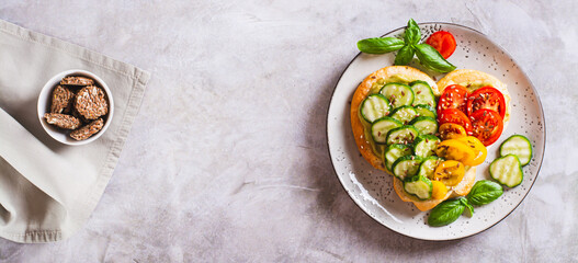 Bruschetta heart with guacomole, tomatoes and cucumber on a plate top view web banner