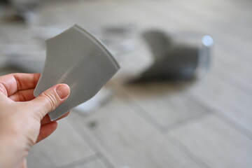 gray fragment of a vase in hands against the background of a broken vase