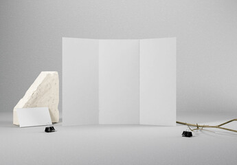 a blank trifold brochure with business card including paper texture and concrete background, great for mockups.