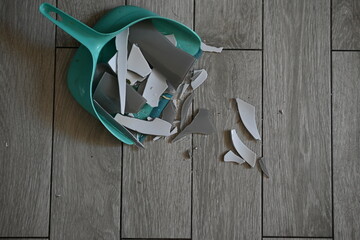 broken glassware on the floor is collected in a garbage scoop, the consequences of a quarrel are...