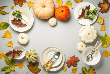Thanksgiving festive table composition with different colourful pumpkins, autumn leaves, empty...