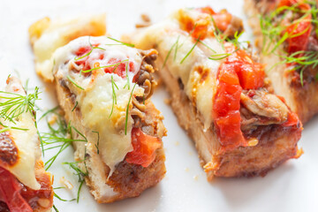 Sliced chicken breast with mushrooms, tomatoes, and mozzarella decorated with dills