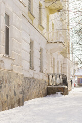 Fototapeta premium Street with building cold weather. Snow day in winter. Building in city center covered with snow.