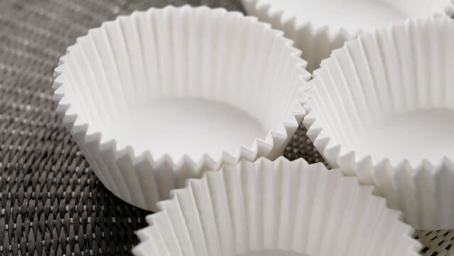 Cupcake and muffins corrugated paper molds. Empty stacked kitchen tools for sweet pastries. Rotation