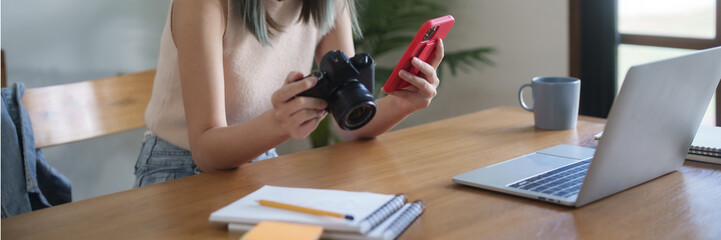 Creative designer woman checking photo on smartphone and working graphic design in home studio..
