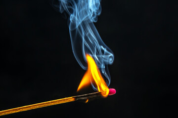 Fire and smoke. Burning and smoking match on a black background. Heat and light from fire flame