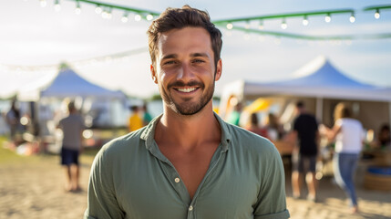 Portrait of a smiling man on the beach against the background of vacationing people - obrazy, fototapety, plakaty