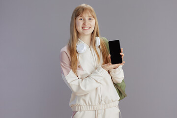 Naklejka premium happy modern teenage girl showing smartphone blank screen