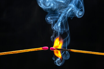 Fire and smoke. Burning and smoking match on a black background. Heat and light from fire flame