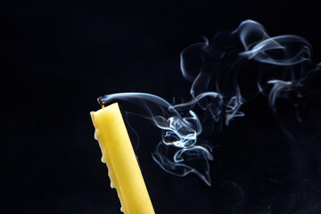 Smoke from an extinguished candle on a dark background. The concept of spirituality and the end of...