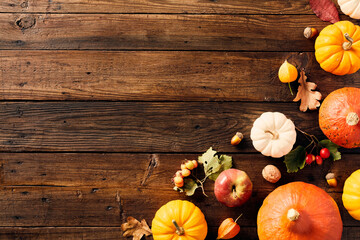 Autumn flat lay composition with pumpkins, acorns, berries, oak leaves on wooden table.