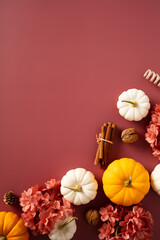 Dark red table with orange pumpkins, flowers, fall decor. Autumn background