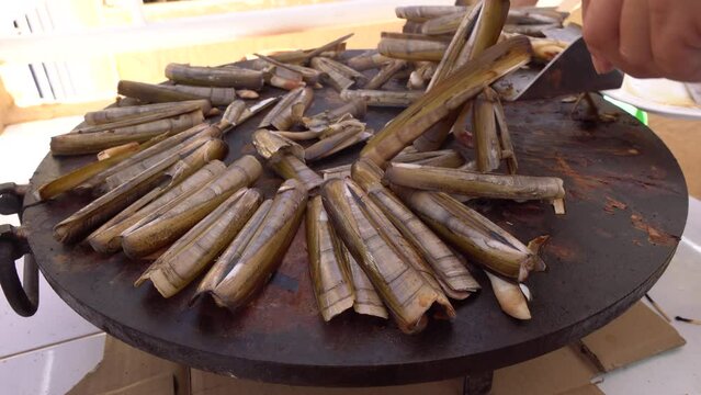 Navajas asadas a la plancha, Ensis ensis, o la navaja de espada, es una almeja navaja, un molusco bivalvo marino de la familia Pharidae. Vive enterrado en la arena y se encuentra frente a las costas d