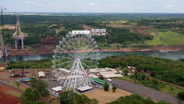 Ferris wheel at border between Brazil Paraguay and Argentina separated by Paran&aacute; River. Ponte da Integra&ccedil;&atilde;o bridge under construction at the background and the Yup Star Roda gigante de foz do Igua&ccedil;u  