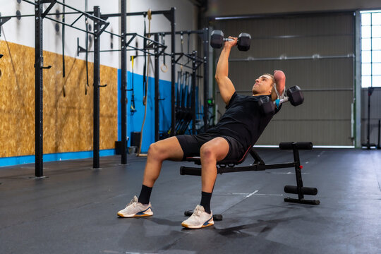 Disabled man exercising with dumbbells in a gym