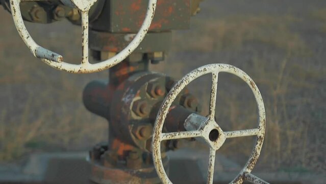 Oil valves an piping of abandoned oil well on the desert
