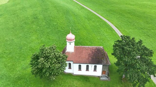 Drohnenvideo von einer kleinen Kirche in einer Wiese von Bayern