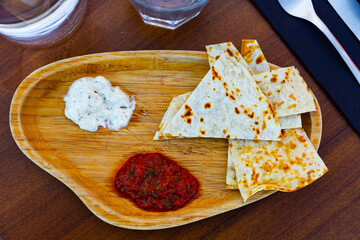 Traditional Arabian appetizer of toasted flatbread served with spicy tomato sauce and piquant garlic tomeya sauce