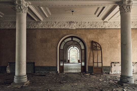 Abandoned soviet spa resort (sanatorium) Shakhter (Miner), in Tskaltubo, Georgia. View of the hall with big columns with orders. Broken arched door
 - Powered by Adobe