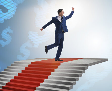 Young businessman climbing stairs and red carpet