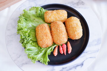 Fried croquettes on a black plate. Selective focus.