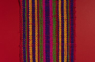 Mexican Tablecloth on red surface woven with natural fibers and bright colors
