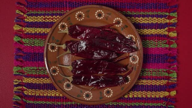 Dried Chilies placing plate on red background with tablecloth mexican spice flat lay