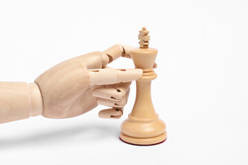 Robot with chess piece on white background. Wooden hand representing artificial intelligence