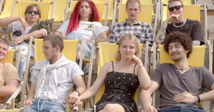 Celebrating differences. Young people sitting, talking on yellow chairs after lectures. Portrait of contemporary youth depicts bold generation. Being authentic in world that celebrates uniqueness.