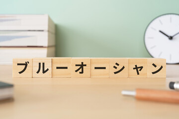 ブルーオーシャンと書かれたブロックが置かれたデスク