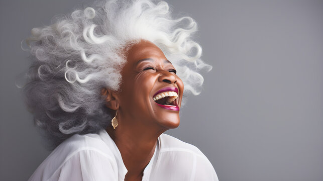 Beautiful senior black woman with white hair, laughing and smiling, reflecting health and beauty with great skin and teeth