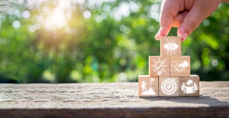 Motivation concept, Person hand holding wooden block on desk with motivation icon on virtual screen.