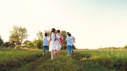 Naklejka na ściany i meble Happy little children with parents run together across lush meadow on vacation