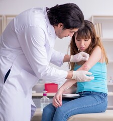 Obraz premium Young arm injured woman visiting young doctor traumatologist