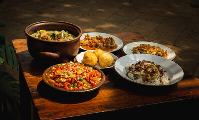 wooden table with indonesian cuisine, nasi telor, sambal matah, sayur lodeh, typical lunch in indonesia