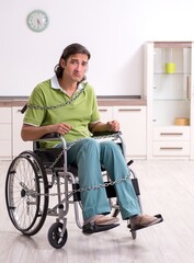Young male invalid in wheel-chair suffering at home