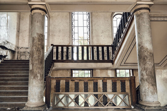 Abandoned soviet spa resort (sanatorium) Shakhter (Miner), in Tskaltubo, Georgia. Antique wooden staircase, arched windows and columns. Stalin Empire style