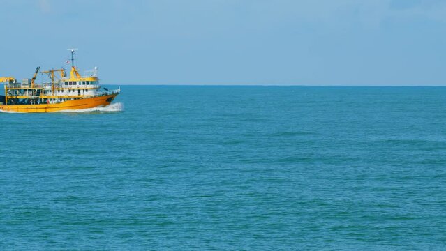Fishing Boat On The Horizon At Sea. Abstract Small Waves On Calm Water Surface In Motion. Real time.