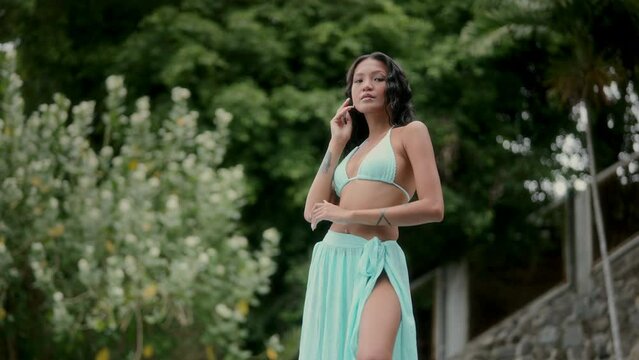 Woman Posing In An Aquamarine Bikini At A Garden