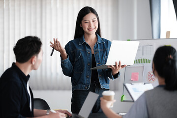 A professional Asian businessman is discussing and brainstorming a new project with his colleagues in the meeting. Startup company, teamwork, modern office