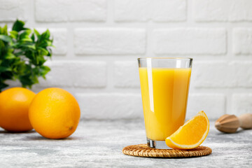 orange juice in glass with slice of fruit on table