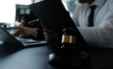 Male lawyer working with contract papers and wooden gavel on tabel in courtroom. justice and law ,attorney, court judge, concept.