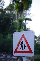 sign on the road with greenery in the background