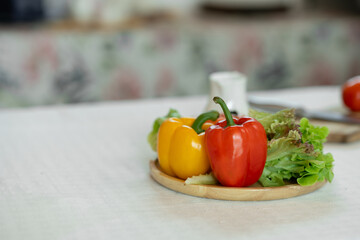 Picture of a kitchen table with wooden chopping boards, knives and fresh vegetables on the table in the kitchen. healthy food concept, vegetarian, diet food