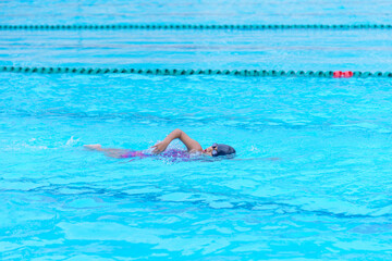child swimmer swim in swimming pool. Water sports training and competition, learning to swim...
