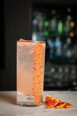 Coctel de frutas en la barra de un bar de lujo con el fondo de diferentes botellas.